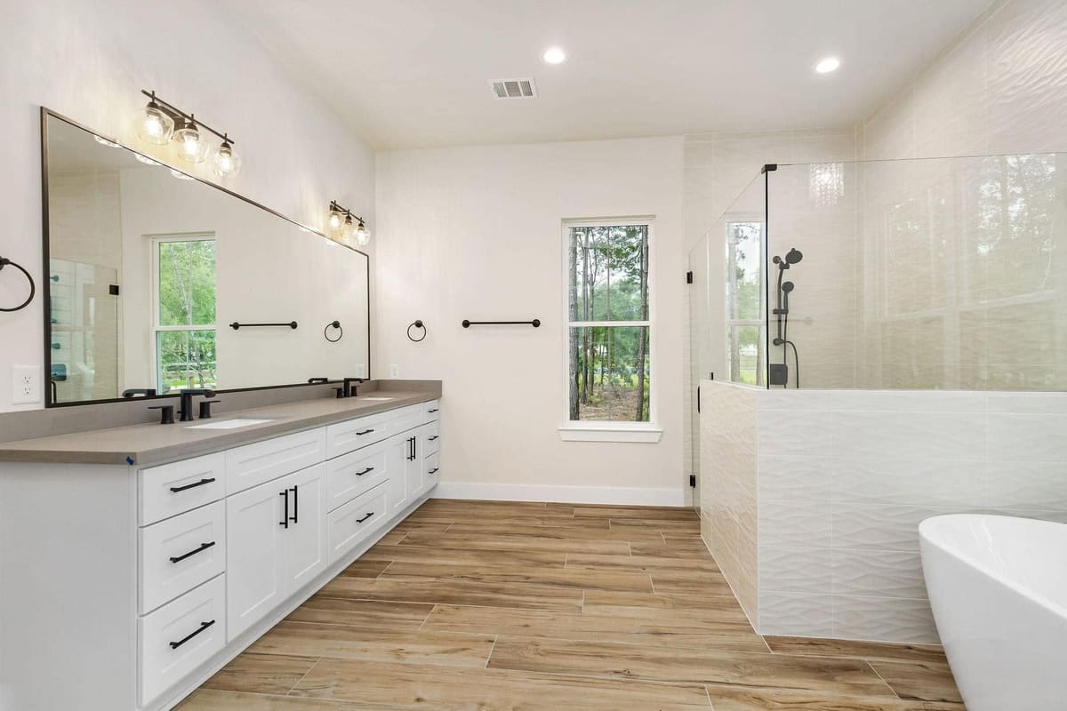 Bathroom with a double vanity, framed mirror and glass shower