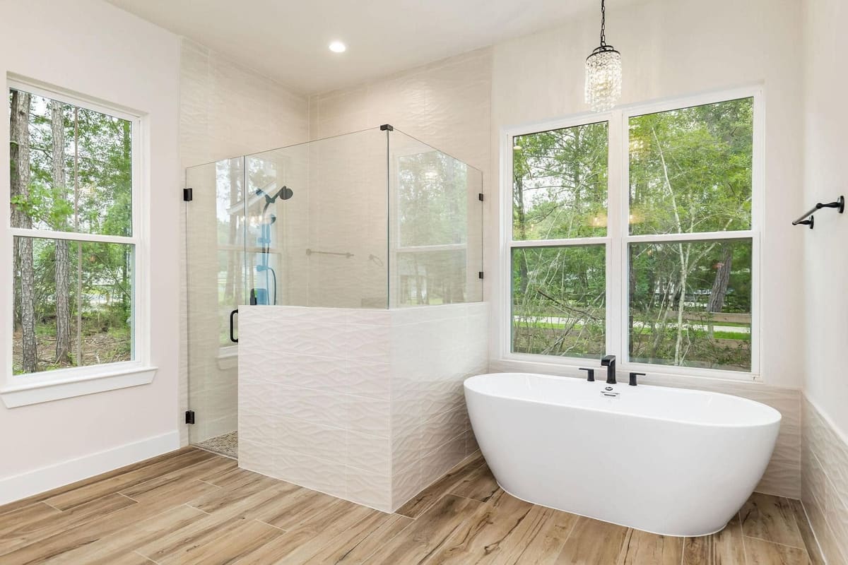 Bathroom with a freestanding tub, glass shower and large windows