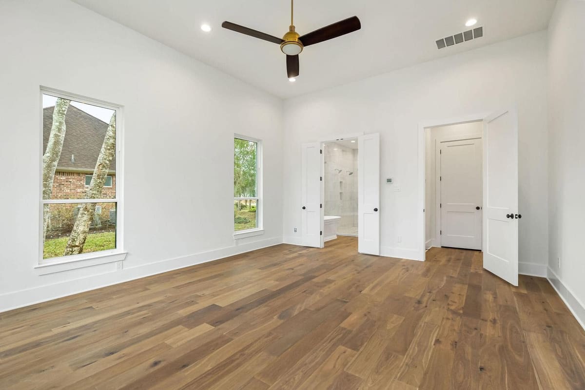 Bedroom with hardwood floors, a ceiling fan and double doors