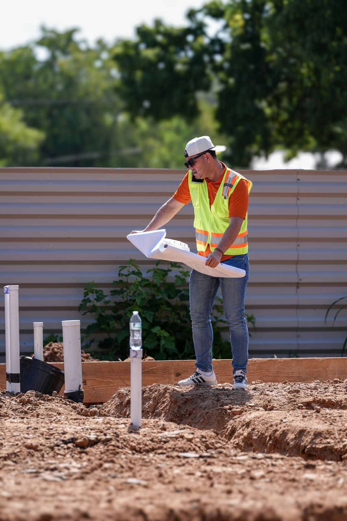 Reviewing the plans on site during plumbing rough-in for a new foundation