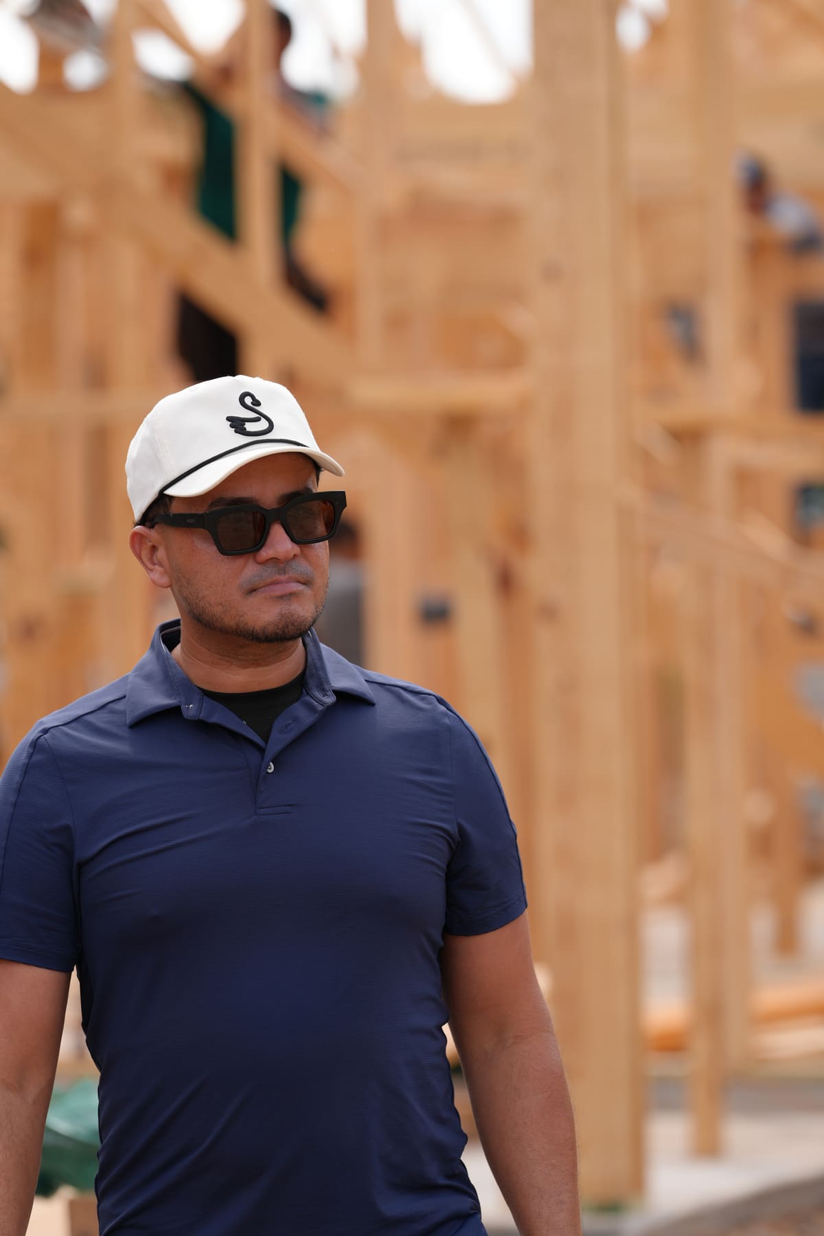 BP Construction Group's contractor on a job site in front of new wall framing