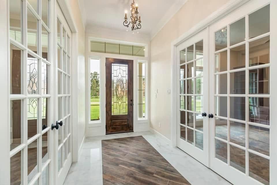 Entry hall with glass French doors on both sides and a leaded-glass front door