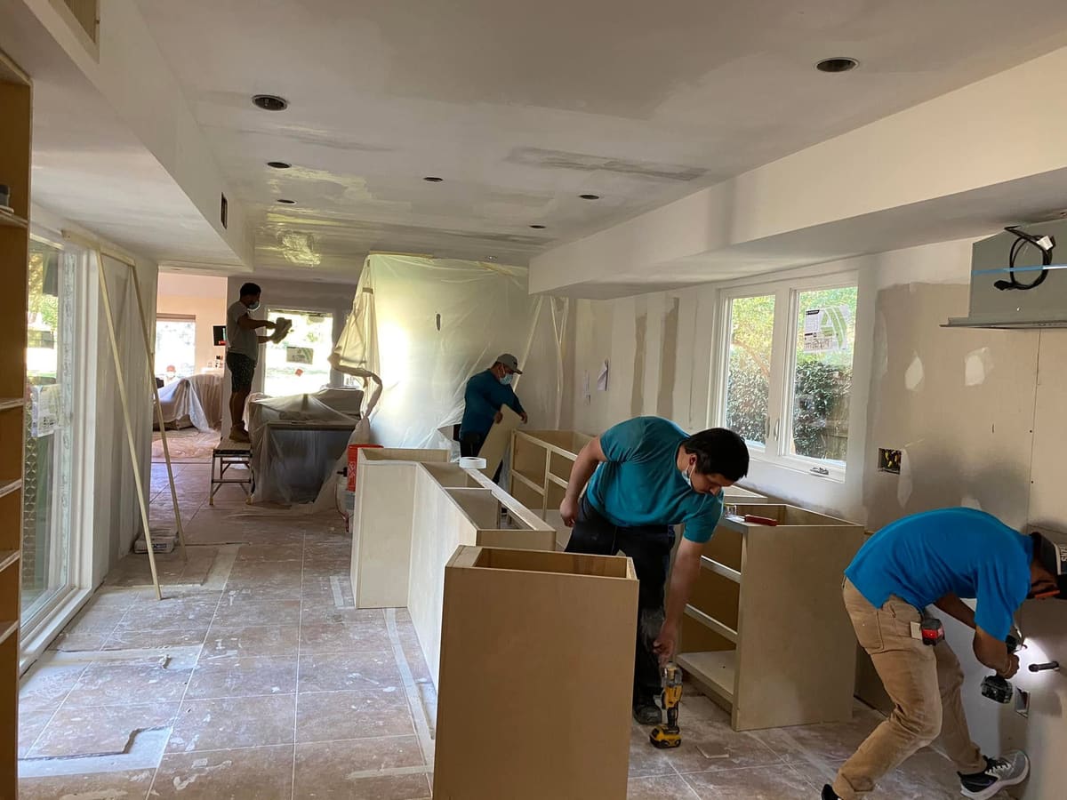 Crew installing base cabinets during a kitchen remodel