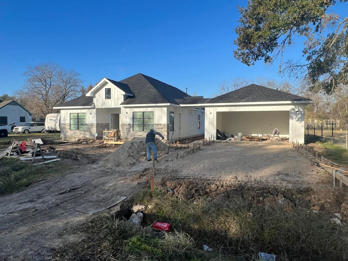 New white home with a two-car garage during final grading of the yard