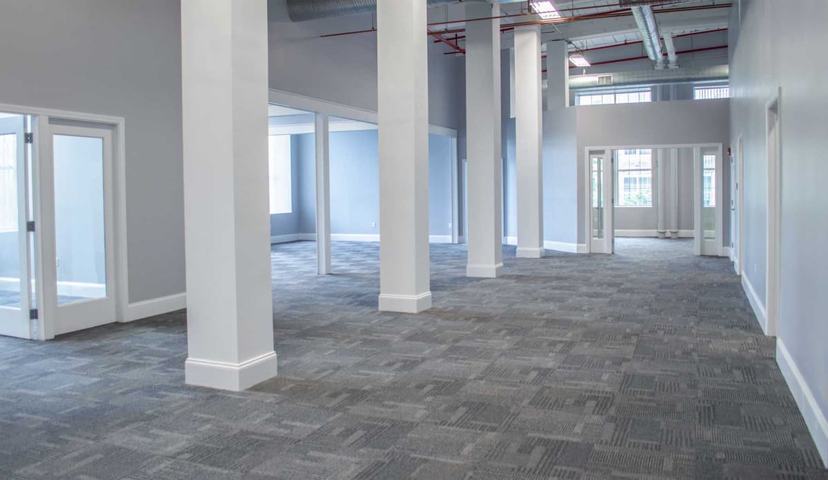 Finished office build-out with glass-front offices, columns and new carpet tile