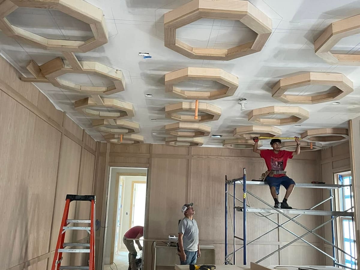 Crew building an octagonal coffered ceiling during a renovation