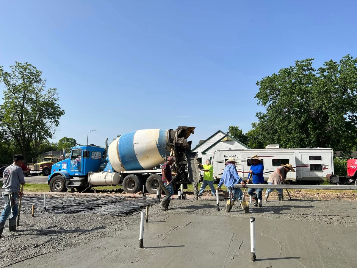Crew screeding a freshly poured foundation slab