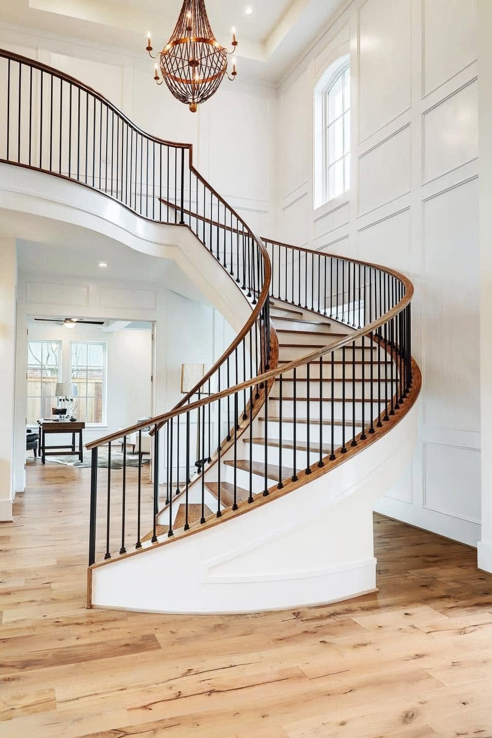 Curved staircase with an iron railing and wood treads in a two-story entry